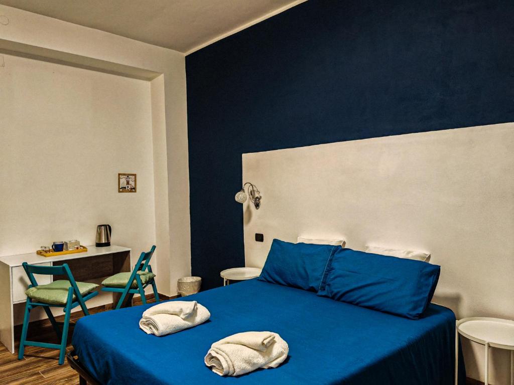 a bedroom with a blue bed with two towels on it at Ament's B&B in Syracuse