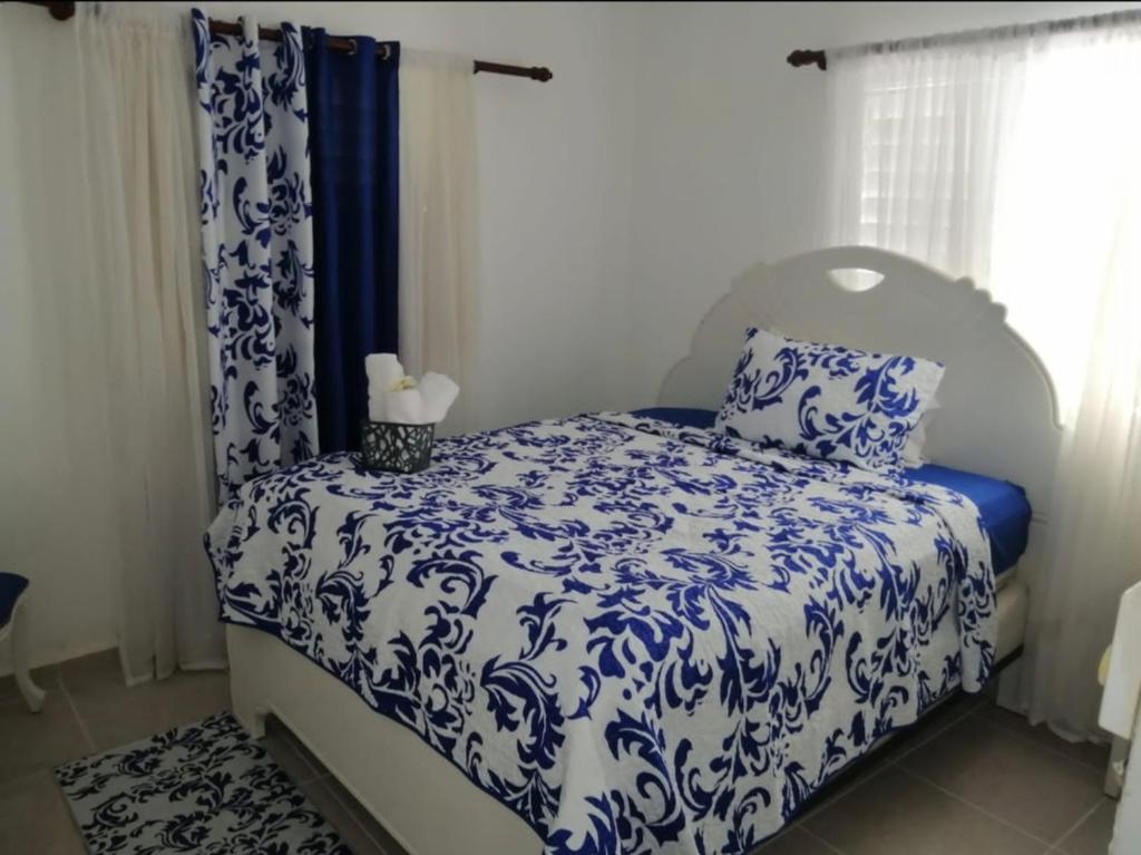 a bedroom with a bed with blue and white sheets at Hermosa casa Holandesa in La Entrada