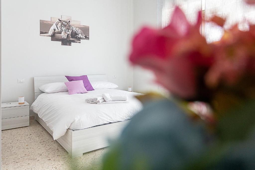 una camera da letto con un letto bianco con cuscini rosa e viola di [Leo's House] smart Tv & Wi-Fi a Campobasso