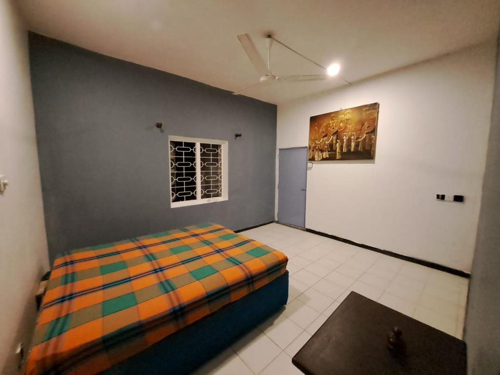 a bedroom with a bed and a painting on the wall at The Lovina Place in Mount Lavinia