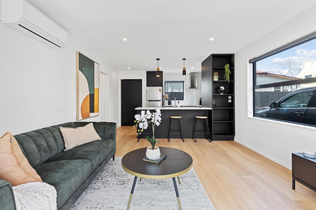 a living room with a couch and a table at Peaceful Elegant Designated Park King Bed in Christchurch