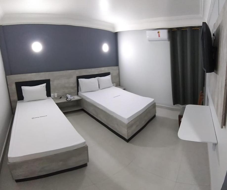 a room with two beds and a tv at Hotel Phizalis in São Caetano do Sul