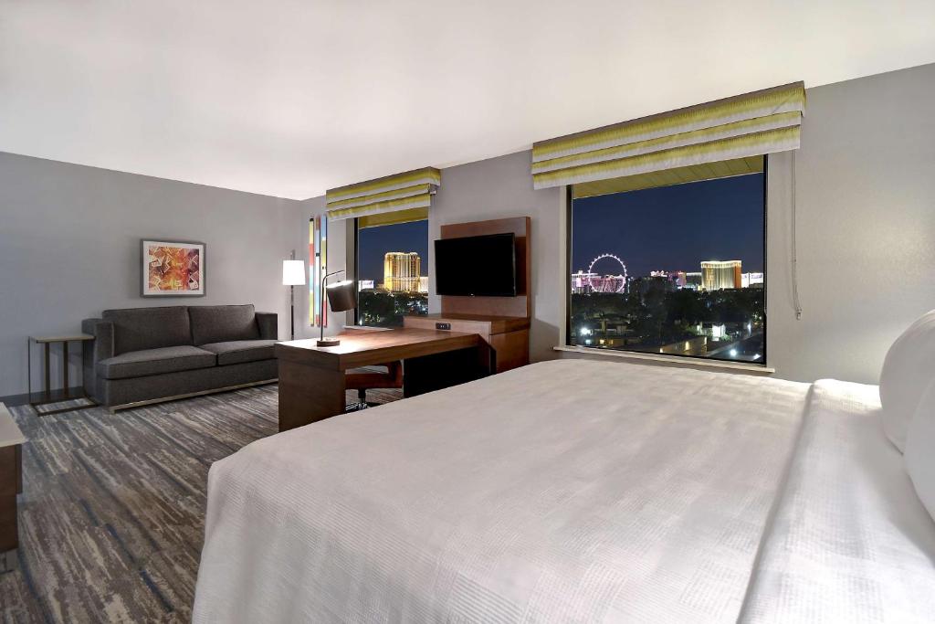 ラスベガスにあるHampton Inn & Suites Las Vegas Convention Center - No Resort Feeのベッドと大きな窓が備わるホテルルームです。