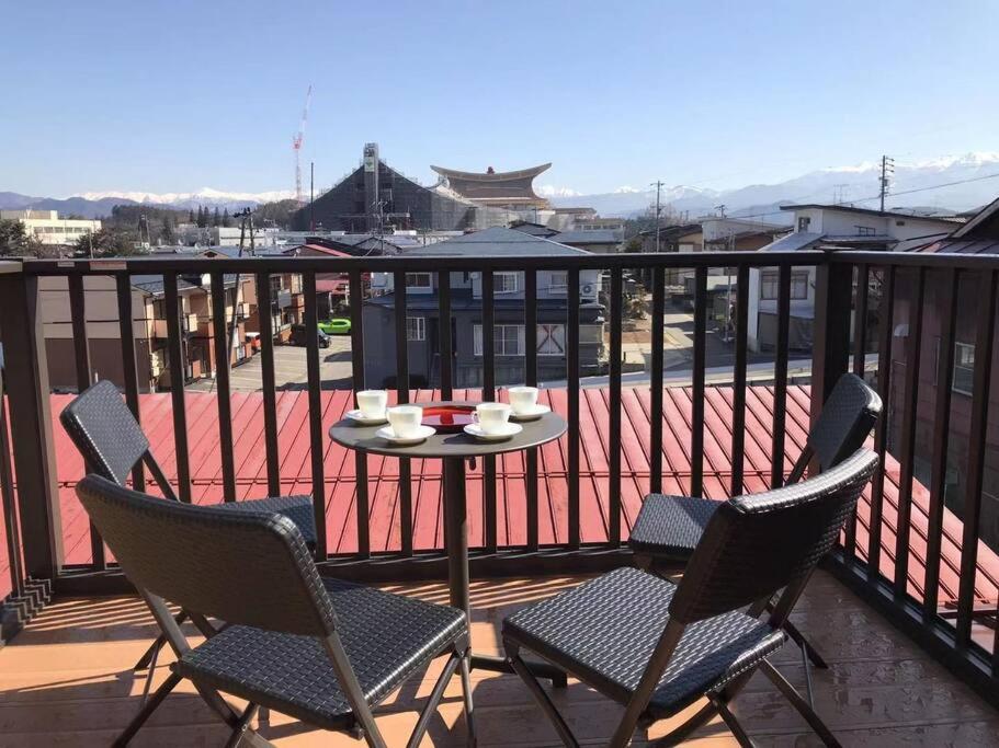 patio con mesa y sillas en el balcón en VILLA TAKAYAMA en Takayama