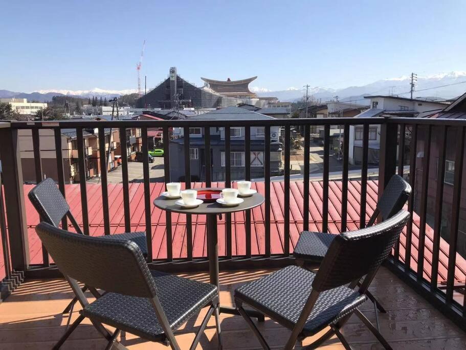 eine Terrasse mit Tisch und Stühlen auf einem Balkon in der Unterkunft VILLA TAKAYAMA in Takayama