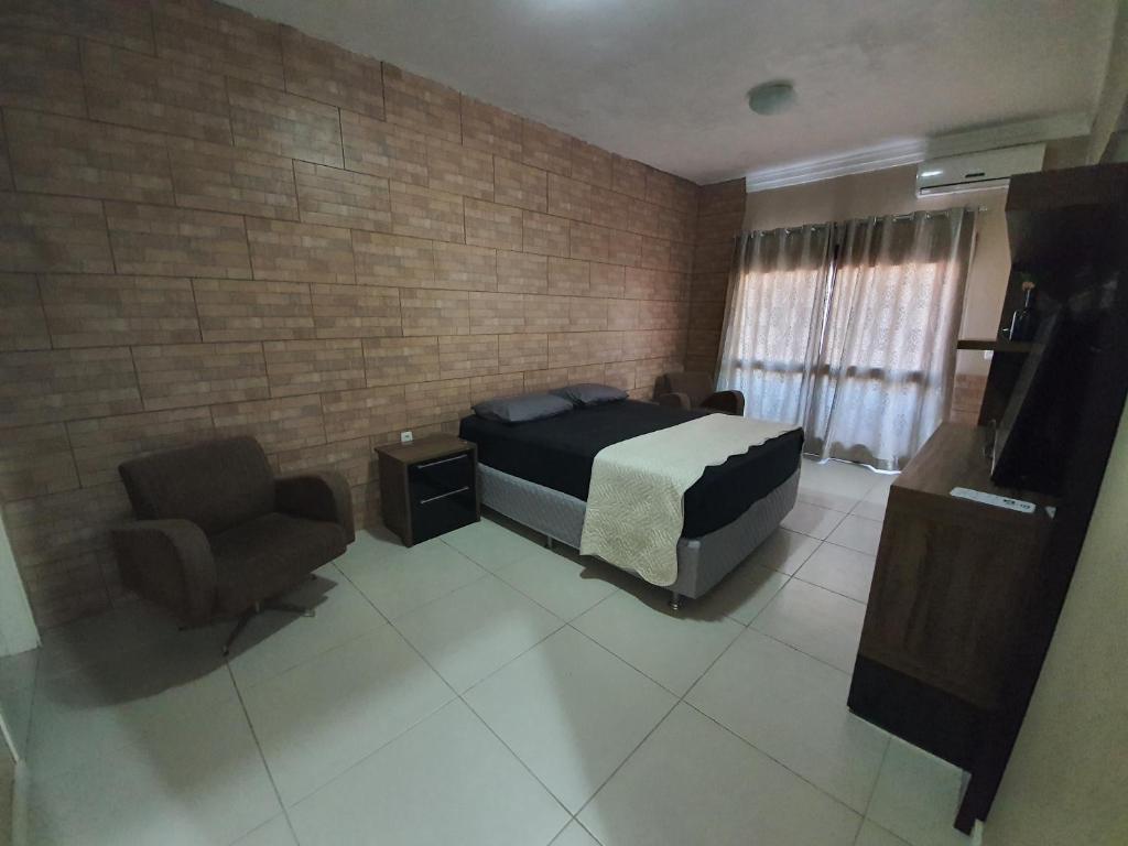 een slaapkamer met een bed en een stoel bij Casa-Ampla Porto Alegre-RS in Porto Alegre