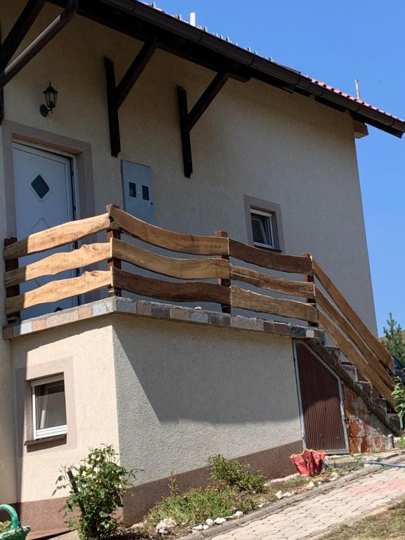 una casa con una terraza de madera en un lateral en Vila Mitic, en Zlatibor
