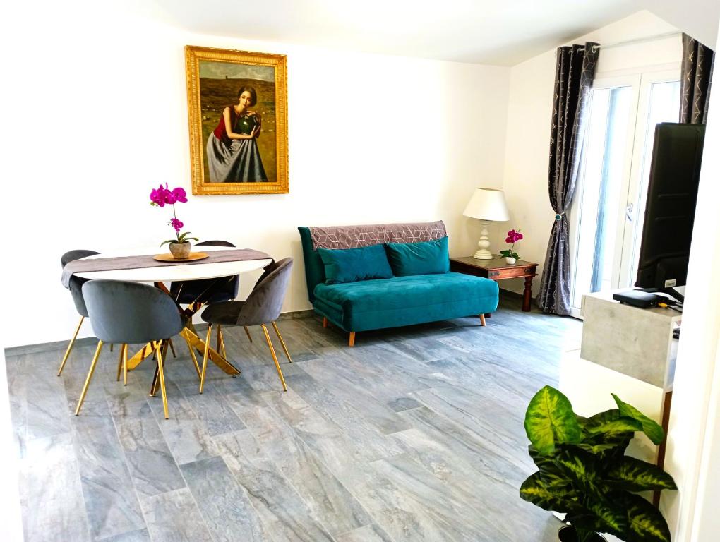 ein Wohnzimmer mit einem blauen Sofa und einem Tisch in der Unterkunft Chic in Fiumicino