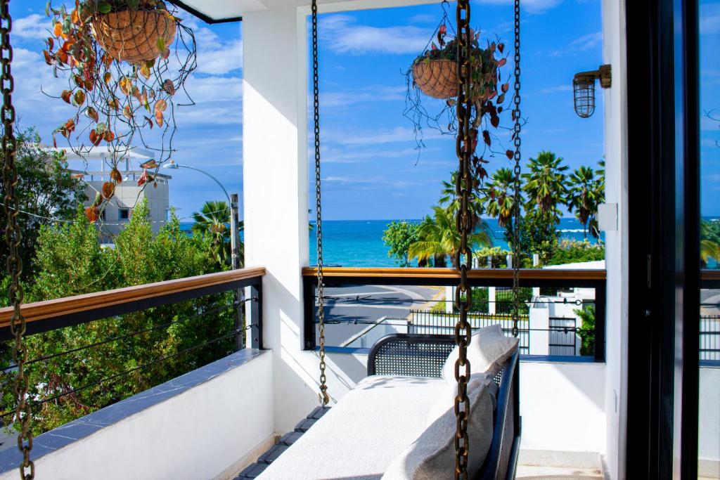 uma varanda com um banco e vista para o oceano em Villa Azure Ocean Park's Seaside Luxe Retreat em San Juan