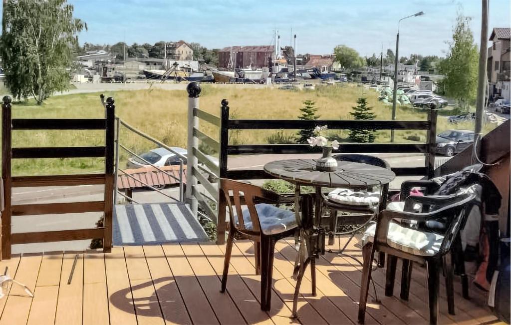a patio with a table and chairs and a view of a field at Awesome Apartment In Leba With Sauna in Łeba