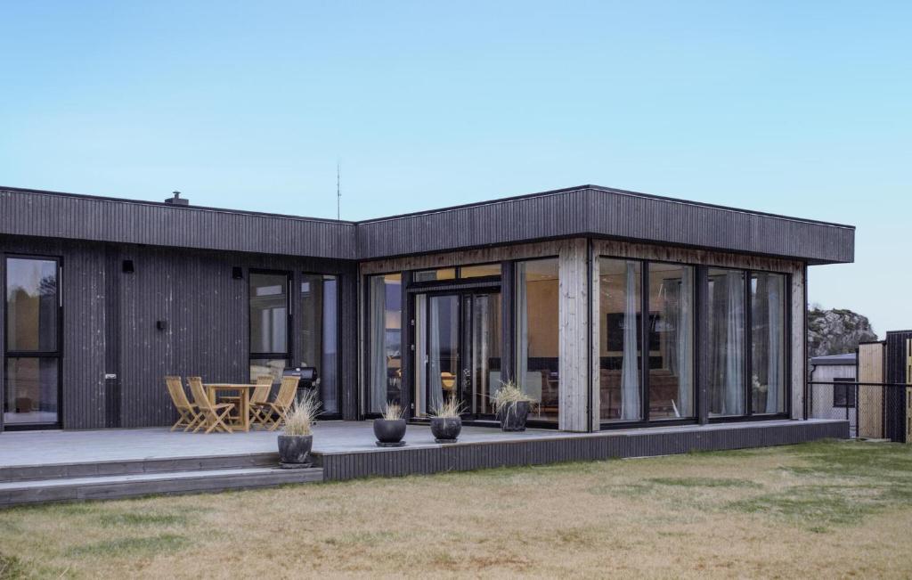 uma casa moderna com portas e janelas de vidro em Lovely Home In Lindesnes With Kitchen em Svenevik