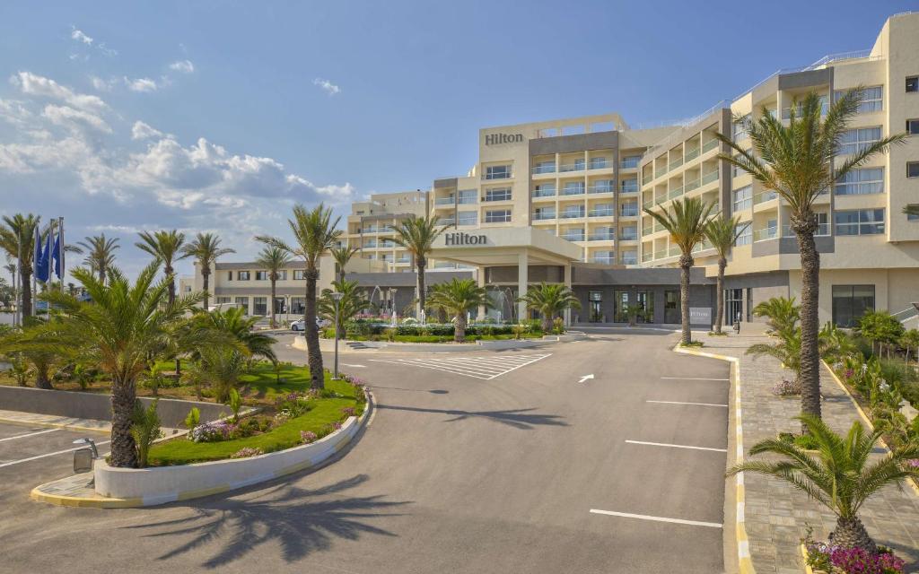 um parque de estacionamento vazio em frente a um hotel em Hilton Skanes Monastir Beach Resort em Monastir