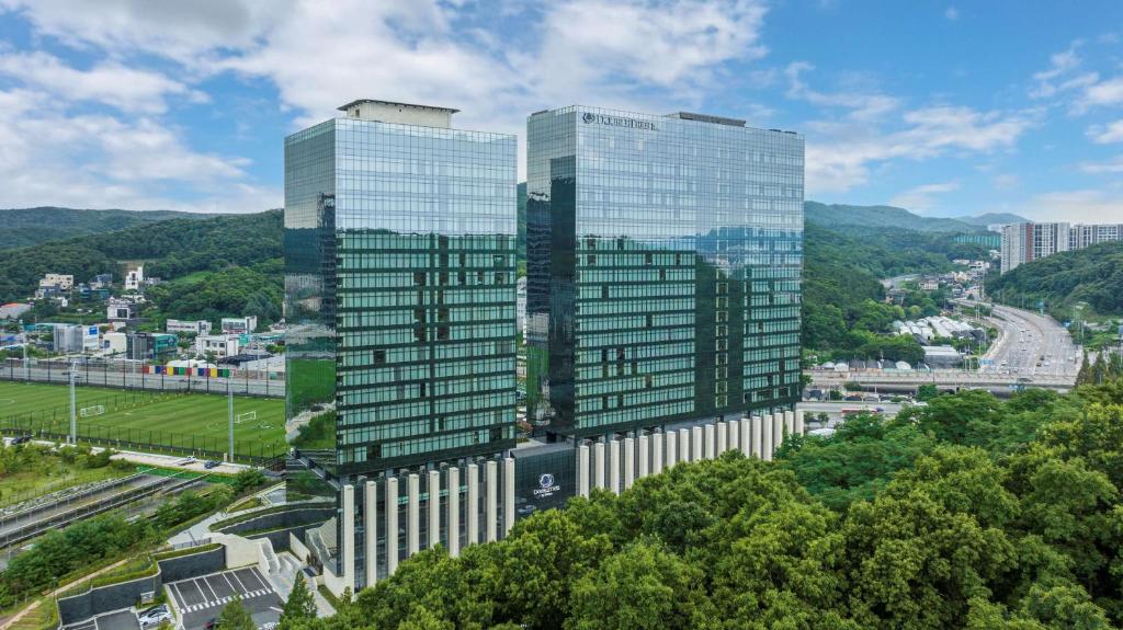 twee hoge glazen wolkenkrabbers in een stad bij DoubleTree By Hilton Seoul Pangyo in Seongnam