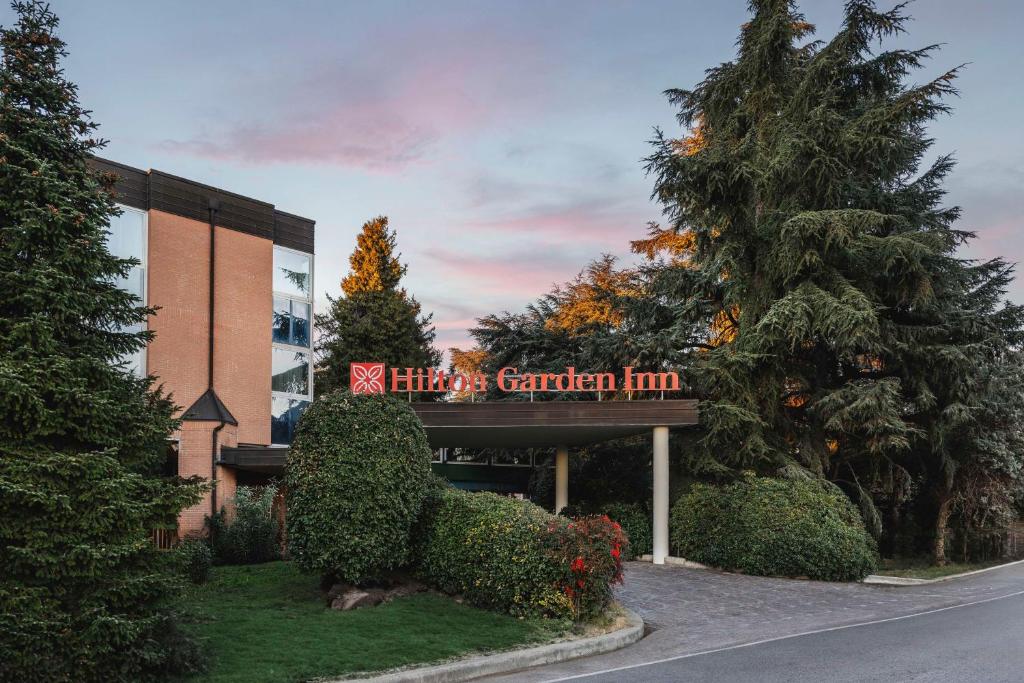 un edificio con un cartel que lee la posada universitaria del jardín en Hilton Garden Inn Bologna North en Bolonia