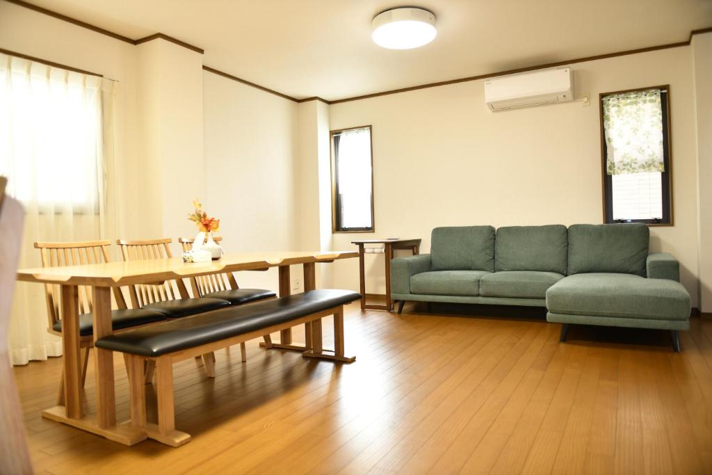 salon z kanapą i stołem w obiekcie Peace & Harmony w mieście Nagoja