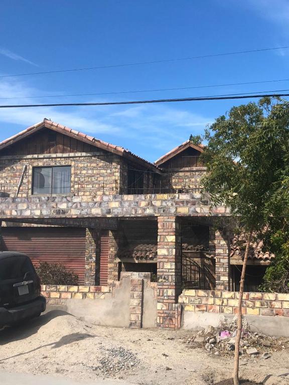 a house with a car parked in front of it at Apartamento Tony Chumpos Superior in San Felipe