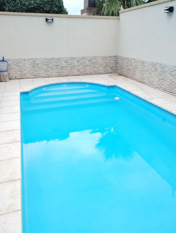 uma piscina com água azul numa casa em Vacaciones familiares em La Cieneguita