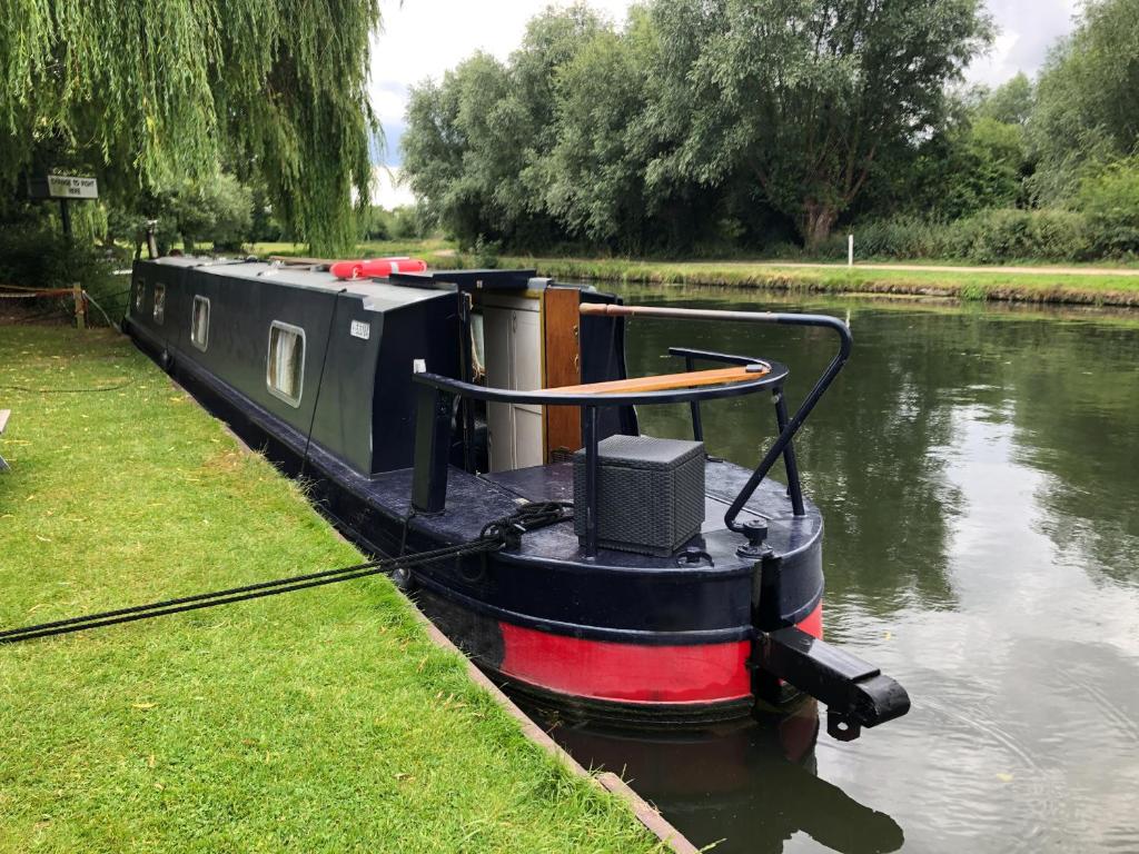 a small boat with a speaker on the side of a river at Beautiful Narrowboat Glyndwr in Cambridge
