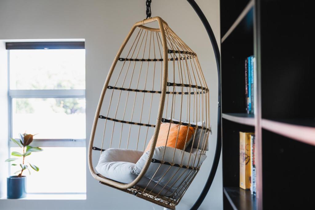 a hanging hammock chair in front of a mirror at Apartment on Manor in Dunedin