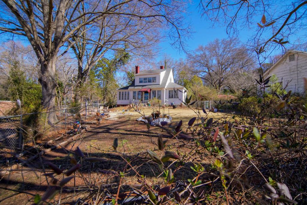 Una casa blanca con un árbol delante. en Healthy Greenery - Urban Retreat in Rock Hill, en Rock Hill