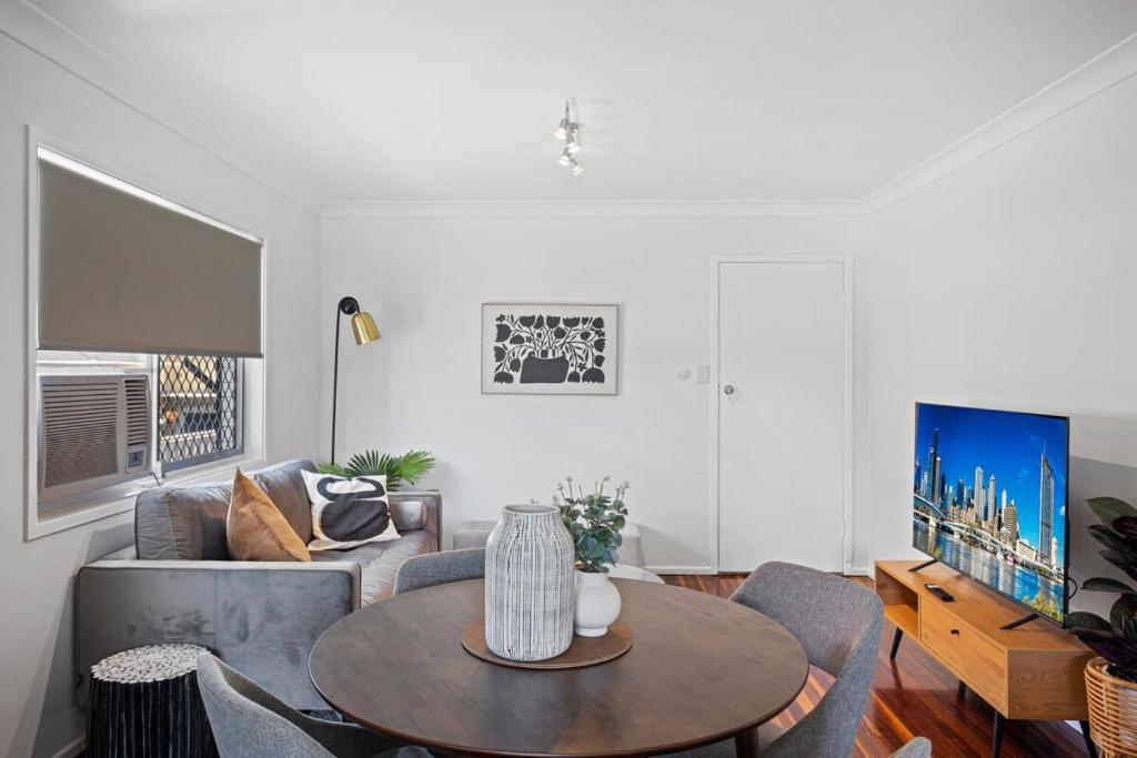 a living room with a table and a couch at Windsor Cosy 2-Bedroom Unit in Quiet Neighborhood in Brisbane