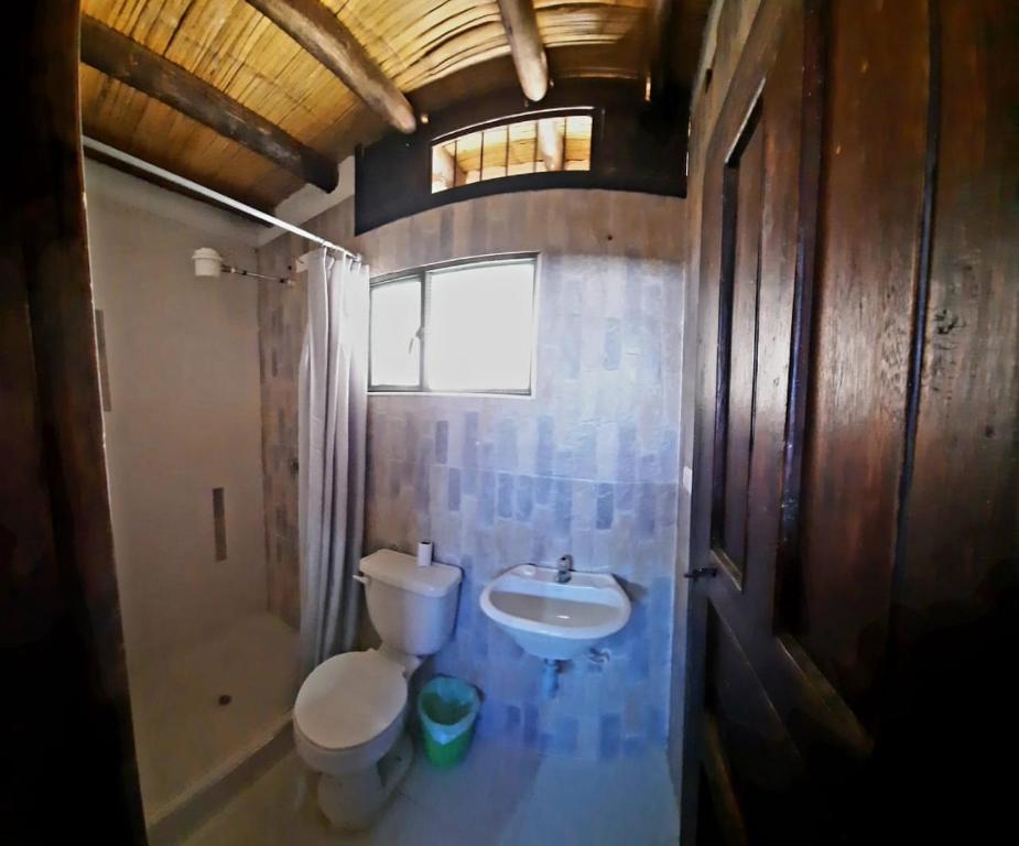 y baño con aseo y lavamanos. en Hostal Oycate, en Oicatá