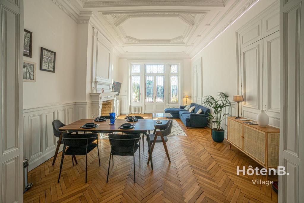 a living room with a table and chairs in it at The "Heritage" Heart of Limoges Parking AC and Private Terrace in Limoges
