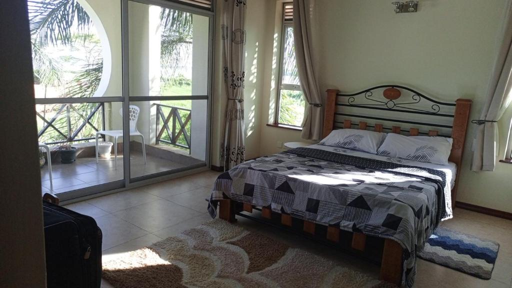 een slaapkamer met een bed en een groot raam bij Luzira port bell lake side apartment in Kampala