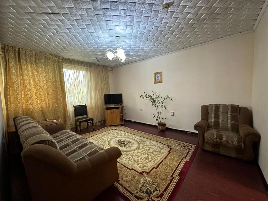 sala de estar con 2 sofás y TV en Гостиничный ресторанный комплекс Эдельвеис, en Öskemen