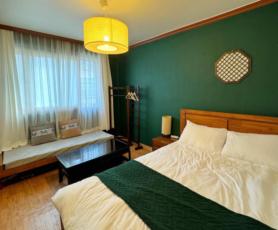 um quarto com uma cama e uma parede verde em La Tulipe em Seul