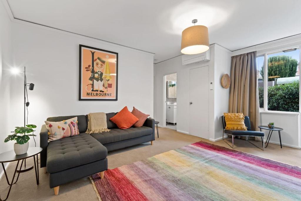 salon z kanapą i kolorowym dywanem w obiekcie Urban Retro - Experience Vibrant Courtyard Charm w Melbourne