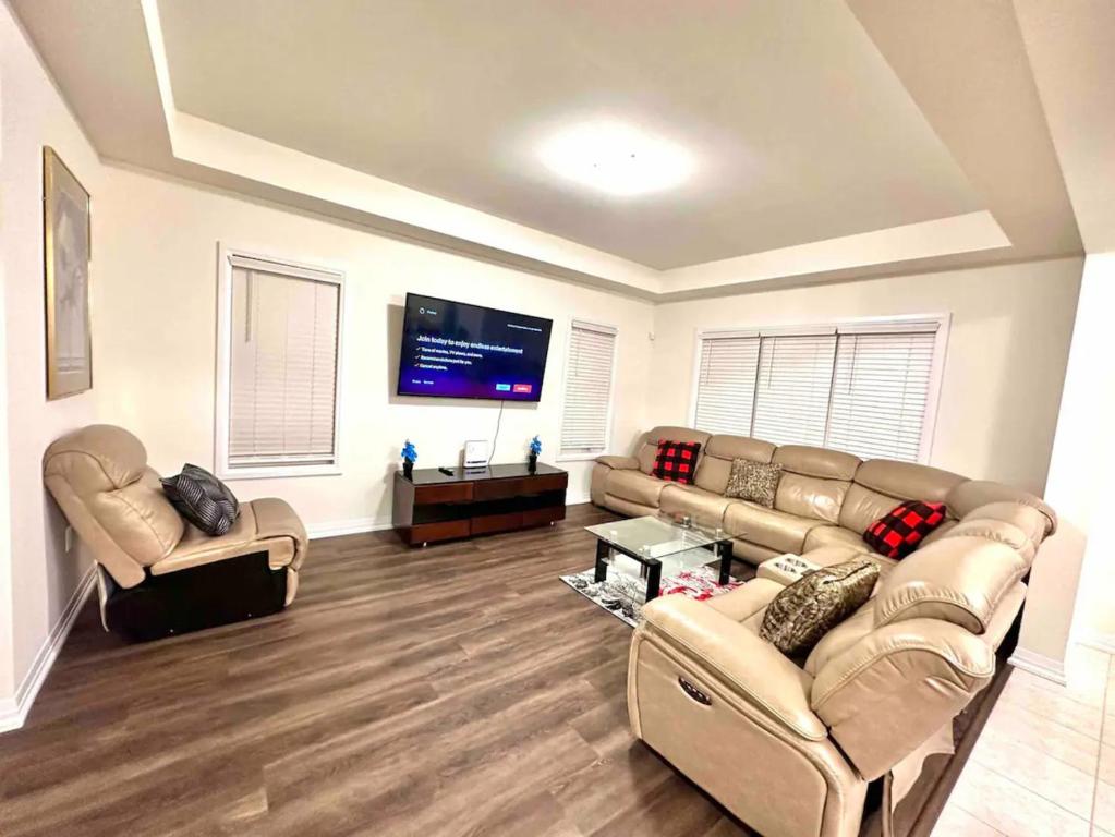 ein Wohnzimmer mit Sofas und einem Flachbildfernseher in der Unterkunft Entire Home In Niagara Falls, Canada in Niagara Falls