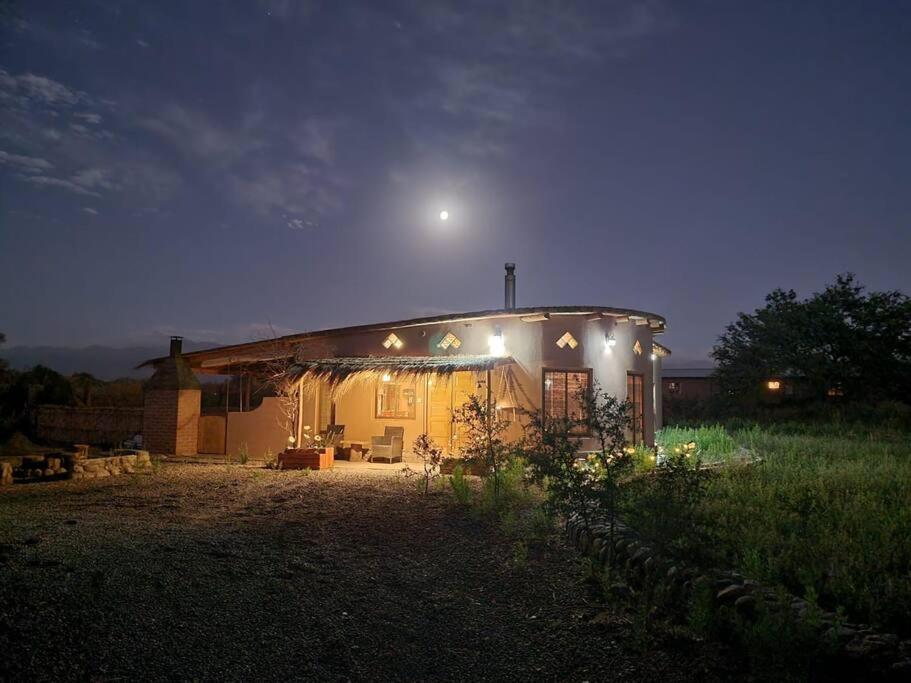 uma pequena casa com luzes à noite em Casa Ohana San Pedro de Atacama em San Pedro de Atacama