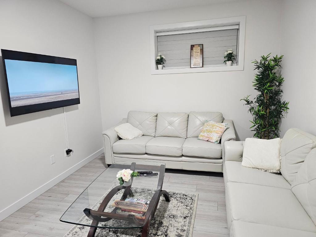 Sala de estar blanca con sofá y mesa en New built house, Stay in Style Guest Suite, 2bedroom, 2bed, 2bath en Edmonton