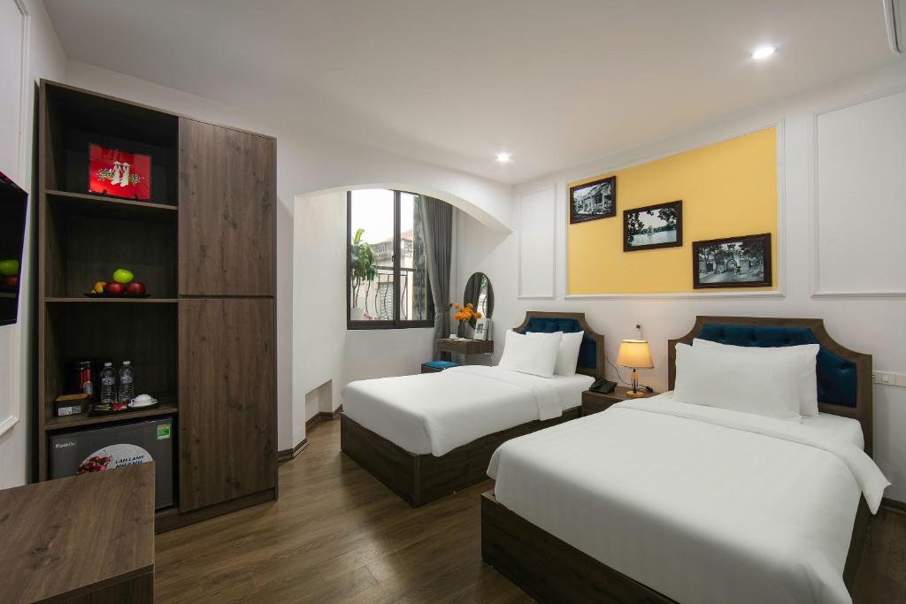 ein Hotelzimmer mit 2 Betten und einem TV in der Unterkunft Dream Boutique Hotel & Travel in Hanoi