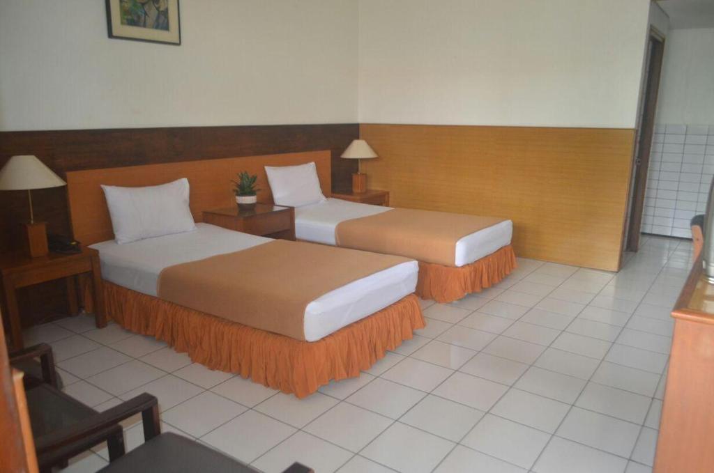 a hotel room with two beds in a room at HOTEL ANEKA BARU in Sleman