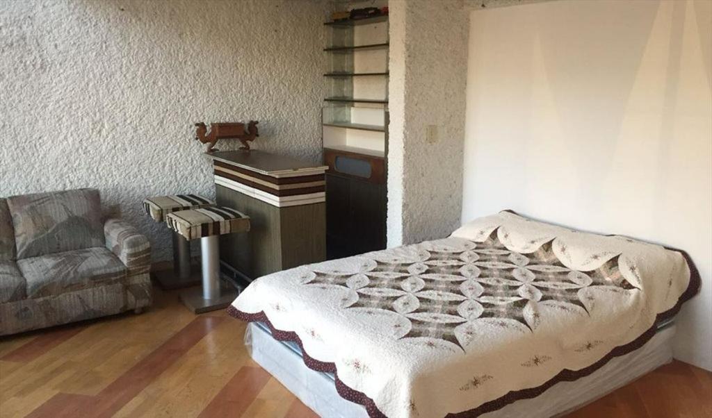 a bedroom with a bed and a desk and a couch at Agradable hogar en Playas de Tijuana in Tijuana