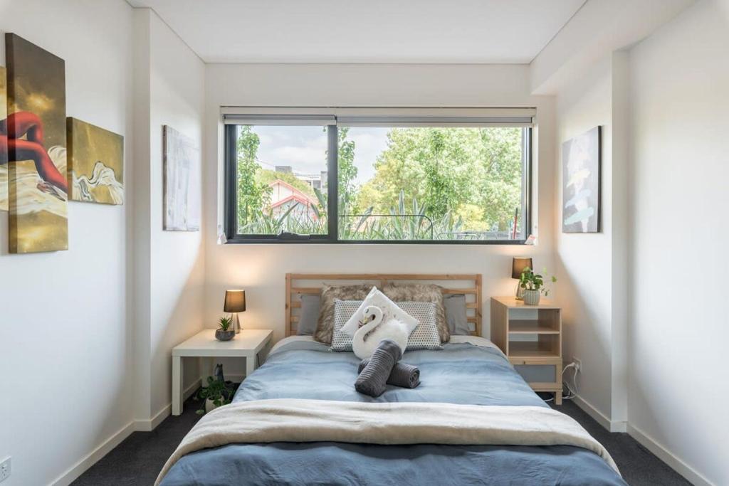 Un dormitorio con una cama con una ventana grande. en 1Bedroom and Study Apt in Homebush Sleeps 5, en Sídney