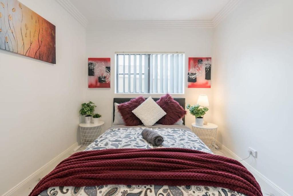 a bedroom with a large bed with red blankets at Cozy Duplex Home 3 Bdrms 1 Bath Sleeps 6 in Glenfield