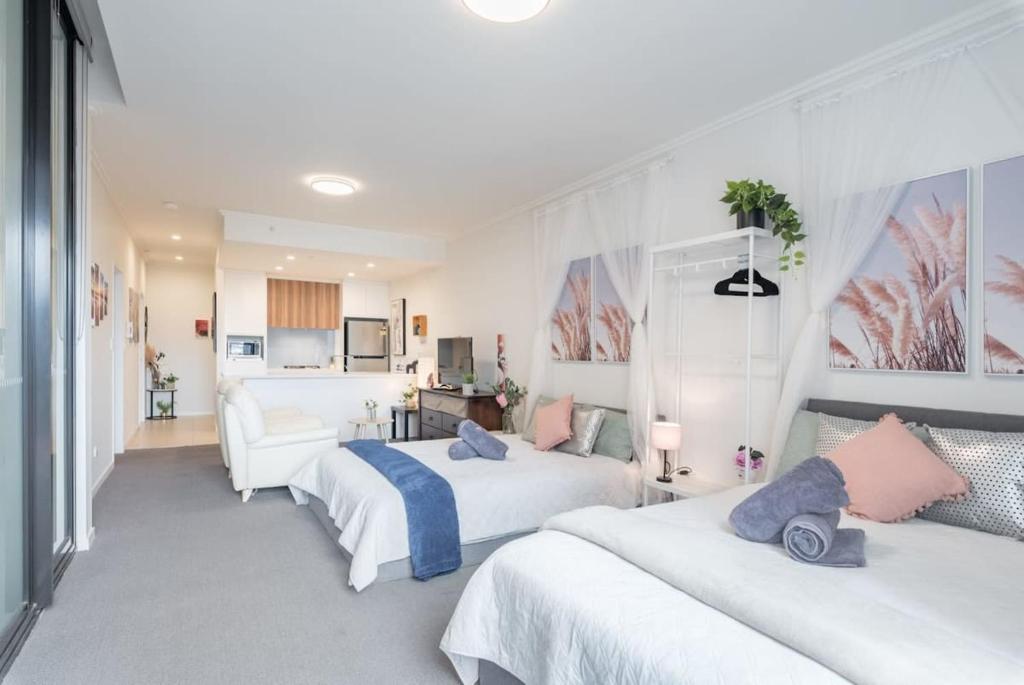 a hotel room with two beds and a couch at 2BR Apt in Hurstville 1Min To Train Station Sleep 8 in Sydney