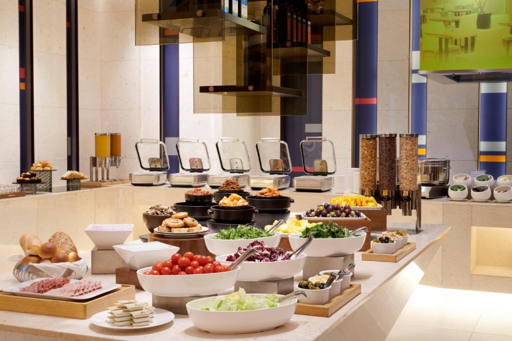a buffet line with bowls of food on display at Aloft Seoul Myeongdong in Seoul