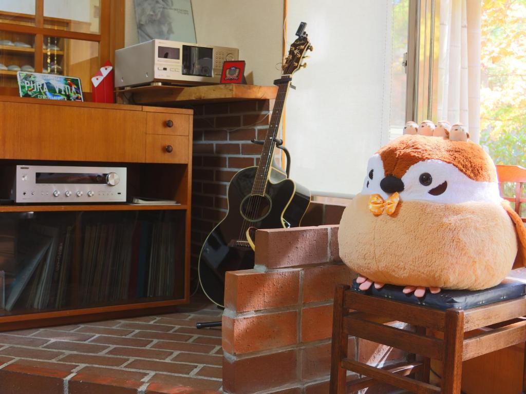 a stuffed animal sitting on a chair in a living room at 雀の宿 やぐら in Matsumoto