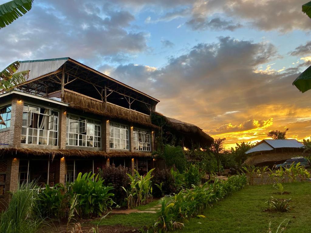 a house with a sunset in the background at Mount Kilimanjaro 360 view Cottage in Uru