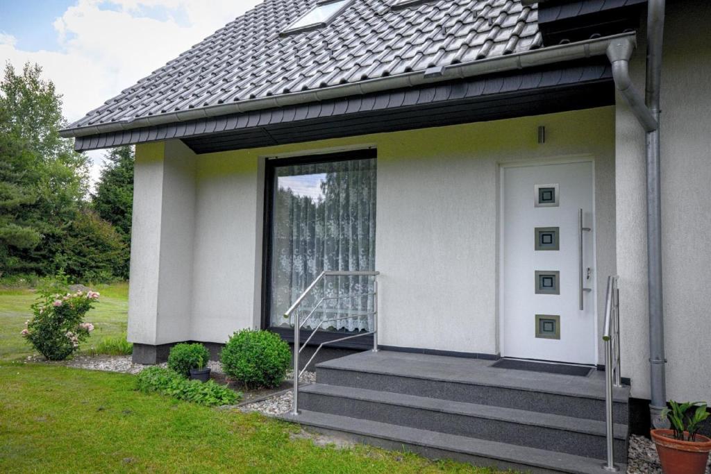 Casa blanca con puerta blanca y escaleras en Appartement in Naterki mit Terrasse, Garten und Grill en Naterki