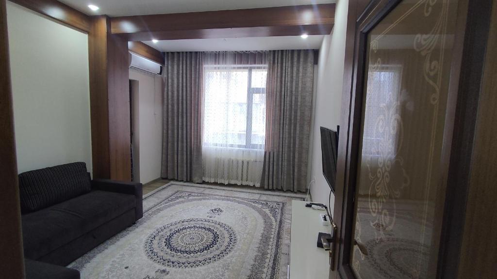 a living room with a couch and a window at Уютная квартирка в центре Душанбе in Dushanbe