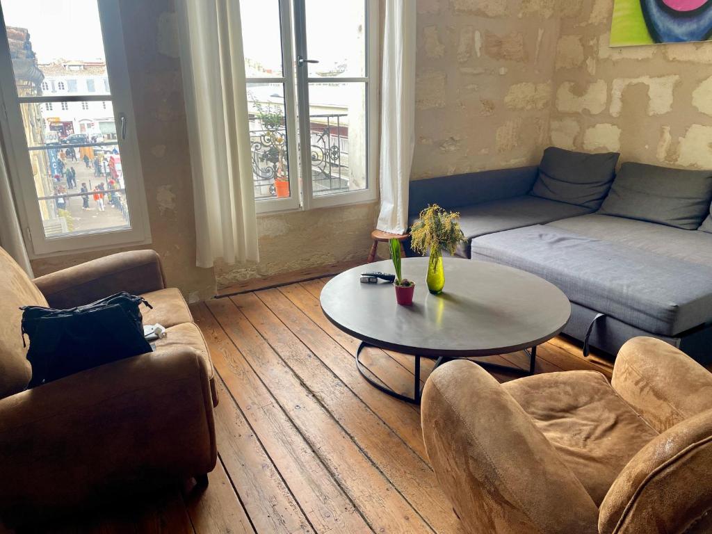 a living room with a couch and a table at Les Capucins in Bordeaux