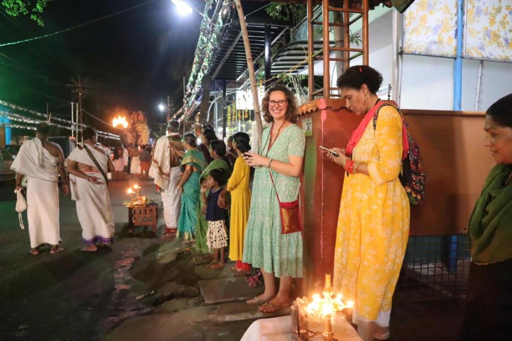 un gruppo di persone in piedi in una folla con luci di Guestland Homestay a Cochin