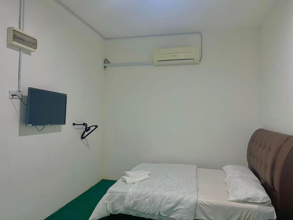 a small room with a bed and a tv at HASD GUESTHOUSE in Kampong Tebing Rabak