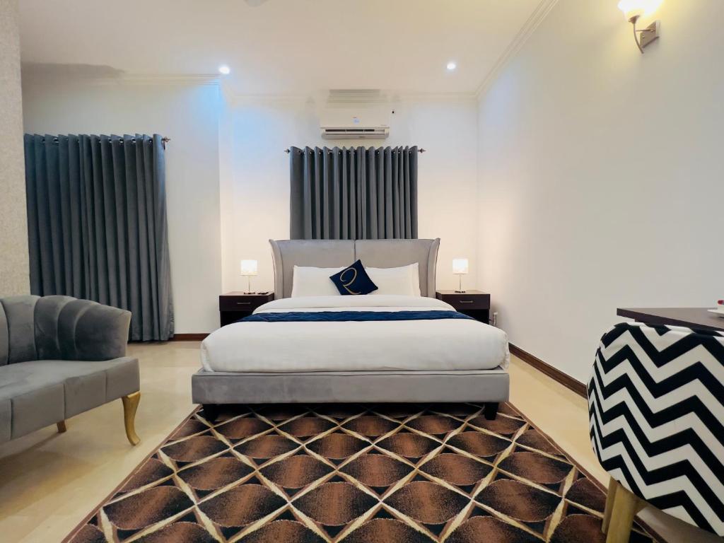 um quarto com uma cama king-size e um sofá em Rhodium Hotel ONE em Islamabad