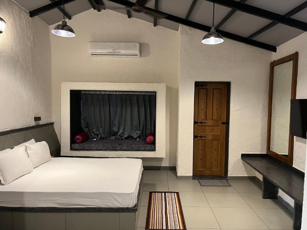 - une chambre avec un lit et une fenêtre avec des tomates dans l'établissement Parnakuti Cottage, à Trimbak